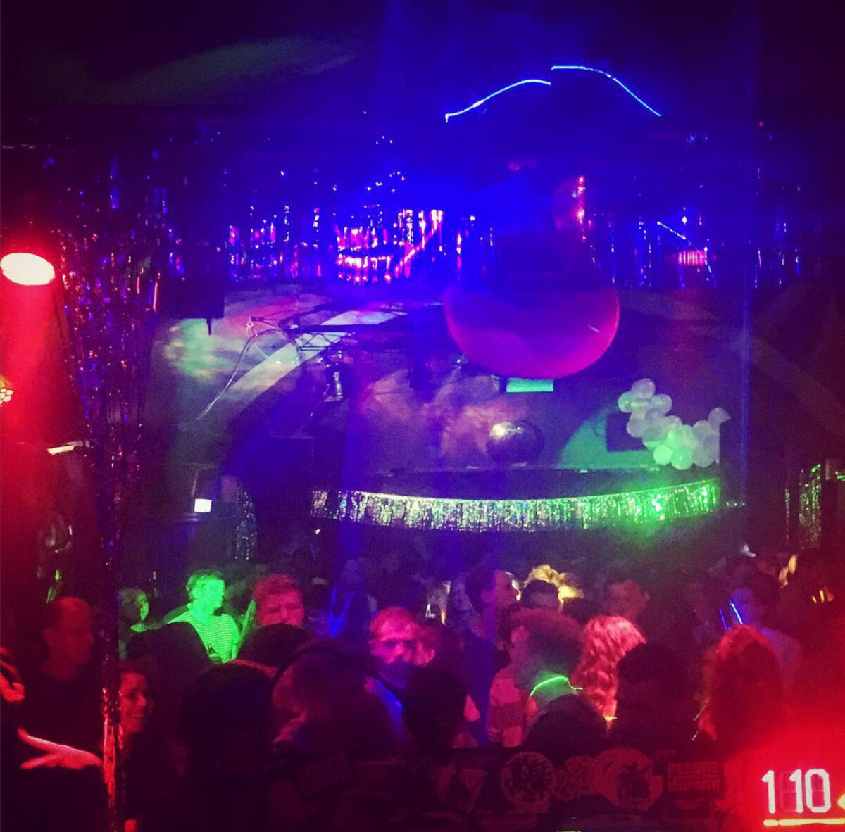 Club room with mirror ball, fairy lights and a crowd in red and green