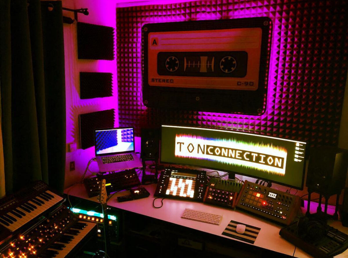 Studio desk with a Moog synthesizer, Elektron machines and a glowing Tonconnection sign on the screen